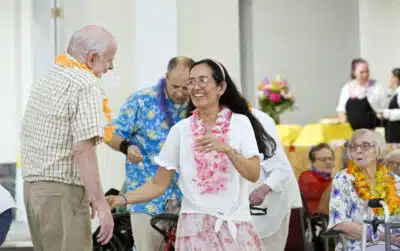 Oak Park Arms resident Mike Clark dances with Veronica Martin during Oak Park Arms Hawaiian theme ballroom dance Friday, August 23, 2024, in Oak Park, Ill.