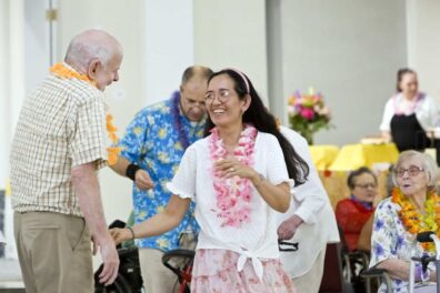 Oak Park Arms resident Mike Clark dances with Veronica Martin during Oak Park Arms Hawaiian theme ballroom dance Friday, August 23, 2024, in Oak Park, Ill.